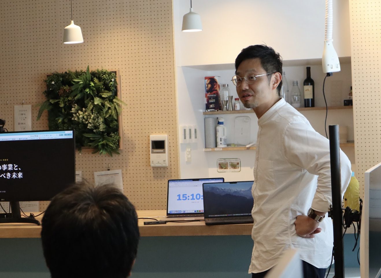 事業展望を語る共同創業者・窪田。モニターには「事業と目指すべき未来」のスライド